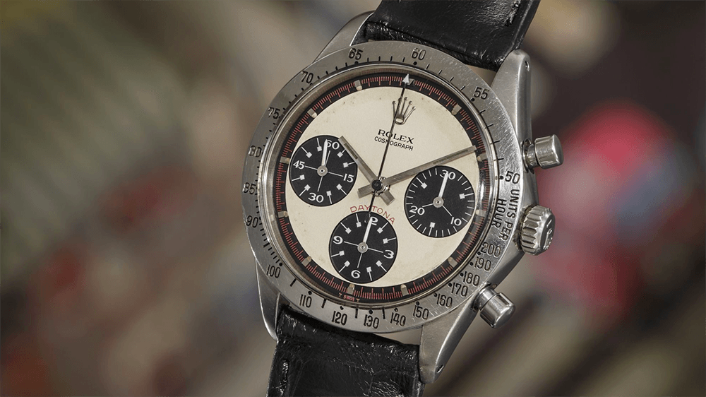 Vintage Rolex Daytona chronograph watch with black leather strap and cream dial