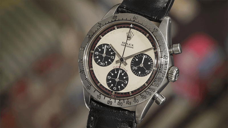 Vintage Rolex Daytona chronograph watch with black leather strap and cream dial