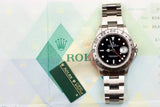 Rolex Explorer II luxury watch with black dial and steel bracelet on a branded background