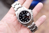 Rolex Explorer II luxury watch with white dial and steel bracelet held in a hand