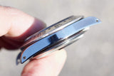 Close-up side view of a luxury Swiss watch bezel and stainless steel case