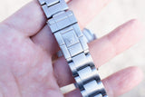 Close-up of a stainless steel luxury watch bracelet clasp with a crown logo