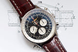 Luxury men's chronograph watch with black dial, silver case, and brown leather strap on sketch