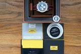 Breitling Navitimer chronograph watch with accessories and documents on wood surface