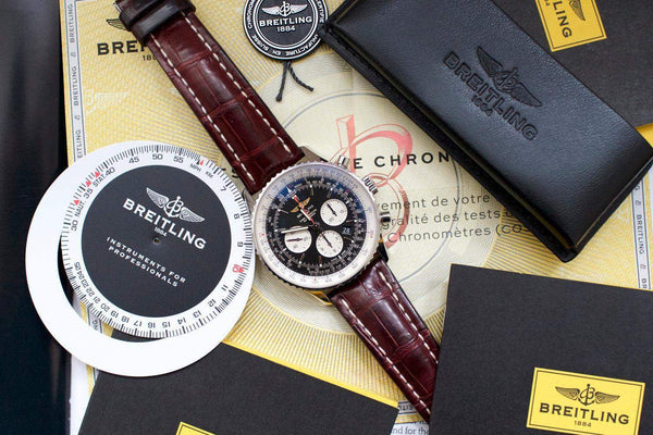 Men’s Breitling chronograph watch with black dial, brown leather strap, and original accessories.
