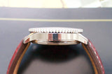 Side profile of a luxury Swiss watch with silver case and brown leather strap