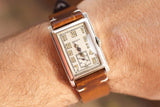 Vintage Gruen rectangular watch with a leather strap on a person's wrist