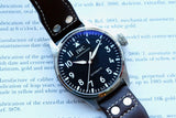 Close-up of an IWC Schaffhausen automatic luxury watch with a black dial and leather strap.