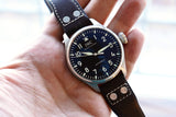 IWC Schaffhausen automatic luxury watch with black dial and brown leather strap on wrist