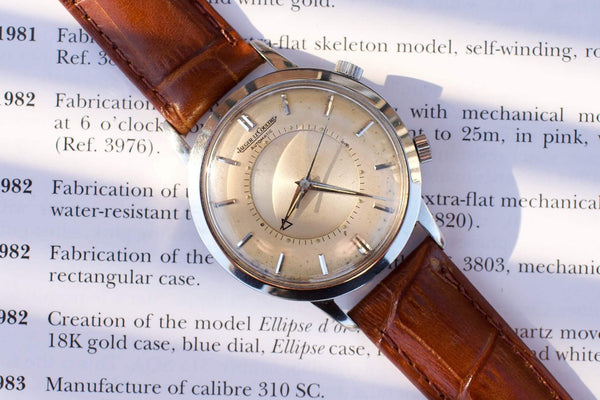 Vintage Jaeger LeCoultre automatic watch with a brown leather strap on a text background.