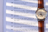 Jaeger-LeCoultre automatic watch with a white dial and brown leather strap on a history page.