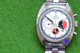 Close-up of a vintage Omega Seamaster chronograph watch with a silver dial and red accents.