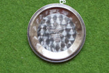 Detailed view of the stainless steel case back of a Swiss-made Omega watch on green fabric.