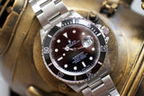 Stainless steel luxury dive watch with black bezel and date window close-up