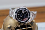 Stainless steel Rolex Submariner 16610 with black dial and unidirectional bezel on display