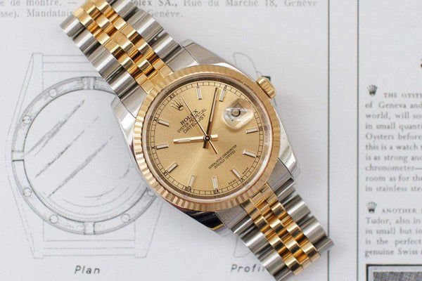 Two-tone luxury watch with champagne dial and jubilee bracelet on technical drawing background