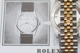 Two-tone stainless steel and gold watch bracelet with crown logo, luxury timepiece close-up