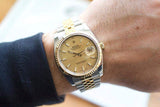 Luxury two-tone gold and stainless steel watch with champagne dial worn on wrist