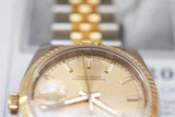 Close-up of a gold and silver luxury watch with a champagne dial and metal bracelet