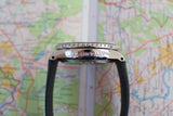 Side view of Blancpain Fifty Fathoms luxury watch with black strap on map background