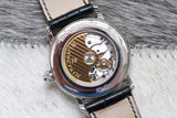 Close-up of luxury Swiss watch caseback showing mechanical movement and leather strap