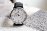 Silver luxury watch with white dial, Roman numerals, black leather strap, and multiple subdials