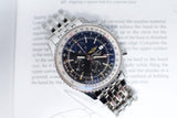 Stainless steel chronograph watch with black dial and silver bracelet on a document background