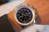 Luxury stainless steel chronograph watch with black dial and multiple subdials on wrist