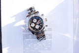 Silver luxury chronograph watch with a blue dial resting on a white document