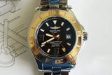 Close-up of a luxury 44mm stainless steel and gold Swiss automatic watch with black dial