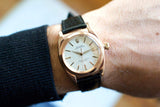 Vintage rose gold Rolex Oyster Perpetual Bubble Back watch with leather strap on wrist