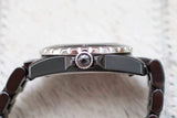 Side view of a luxury ceramic wristwatch with a textured bezel and black strap