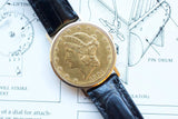 Luxury gold coin watch featuring a 1904 Liberty Head design on a black leather strap.