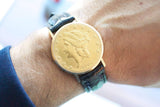 Close-up of a 1904 gold coin converted into a luxury wristwatch with a black leather strap