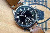 Close-up of an Eberhard & Co luxury watch with a black dial and brown leather strap.