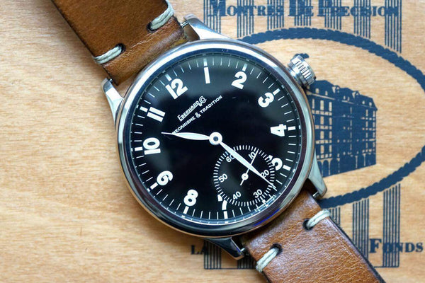 Close-up of an Eberhard & Co luxury watch with a black dial and brown leather strap.