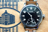 Close-up of an Eberhard & Co luxury watch with a black dial and brown leather strap.