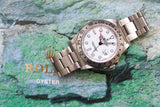 Rolex GMT-Master II luxury watch with white dial and stainless steel bracelet on stone background