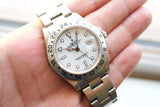 Close-up of a silver Rolex GMT-Master II luxury watch with a white dial and steel bracelet.