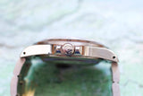 Side profile of a luxury Swiss-made watch showing the crown with crown logo