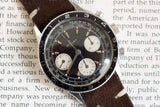 Vintage Gallet pilot chronograph wristwatch with brown leather strap and black dial, close-up on text background