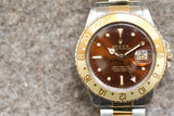 Close-up of a Rolex GMT-Master luxury watch with a brown dial and gold bezel.