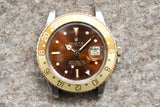 Vintage Rolex GMT-Master watch with brown dial and gold bezel on a textured background