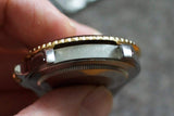 Close-up side view of a luxury gold and silver watch bezel and case