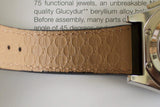 Close-up of a luxury watch with embossed tan leather strap and polished metal case
