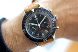 Vintage Heuer Bund SG 1550 flyback chronograph luxury watch with black dial and brown strap on wrist