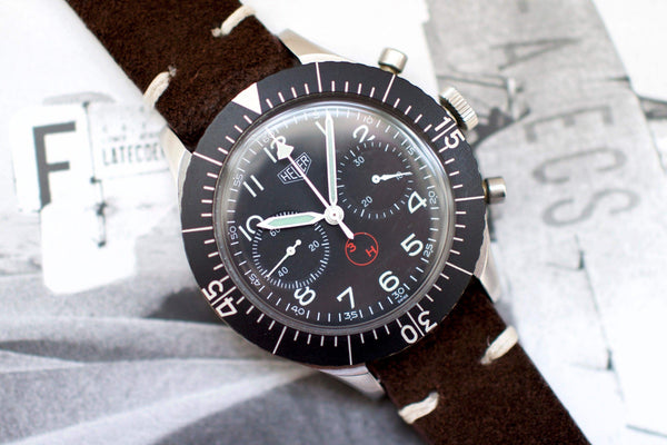 Vintage Heuer Bund SG 1550 flyback chronograph with black dial and brown suede strap.