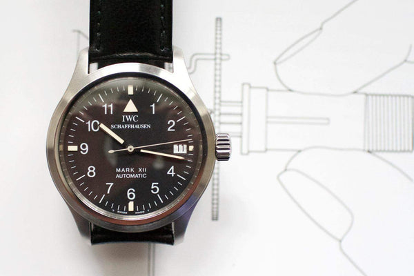 IWC Mark XII men's pilot watch with black dial and leather strap, close-up front view