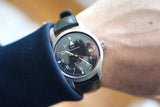 Men’s IWC Mark XII automatic pilot watch with black dial and leather strap on wrist