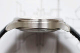 Side profile of a brushed stainless steel men's luxury watch case with black strap